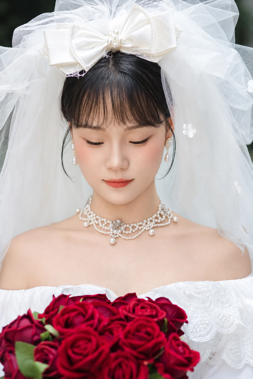 新娘低头看着手中的红玫瑰