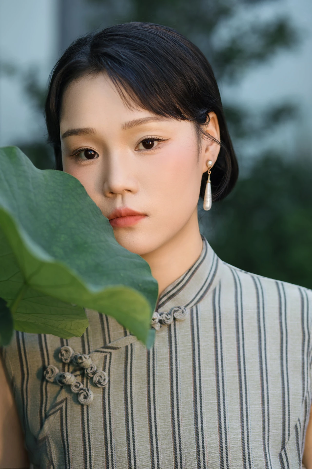 新娘身穿旗袍手持绿叶的肖像